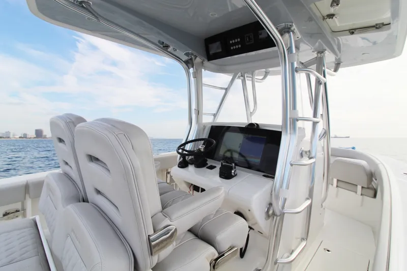 Slide: The Image of 2019 Jupiter 30 HFS boat interior with dual seats and navigation console on open water. - 2