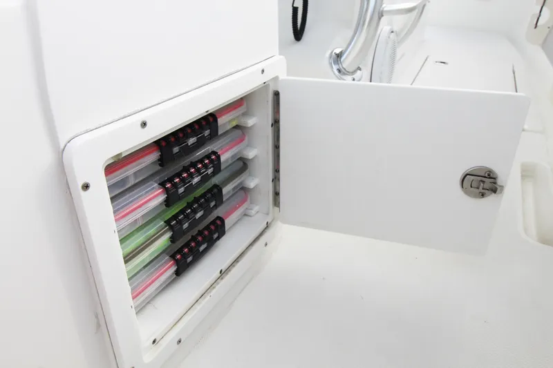 Slide: The Image of Open storage compartment on 2019 Jupiter 30 HFS boat, showcasing organized tackle boxes. - 21