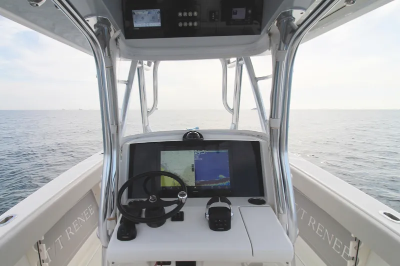 Slide: The Image of 2019 Jupiter 30 HFS boat helm with navigation display, steering wheel, and ocean view. - 5