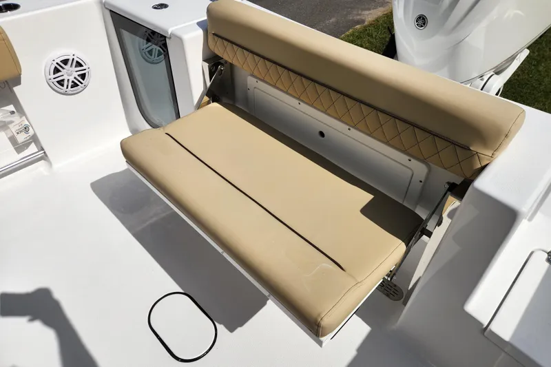 Slide: The Image of 2026 Sportsman Open 232 Center Console boat with tan cushioned seating and speaker. - 18