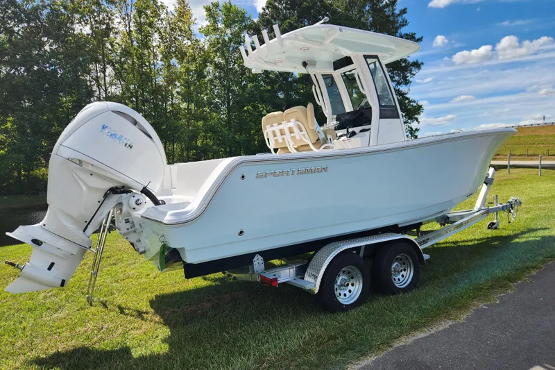 Slide: The Image of 2026 Sportsman Open 232 Center Console boat on trailer, parked on grass. - 2