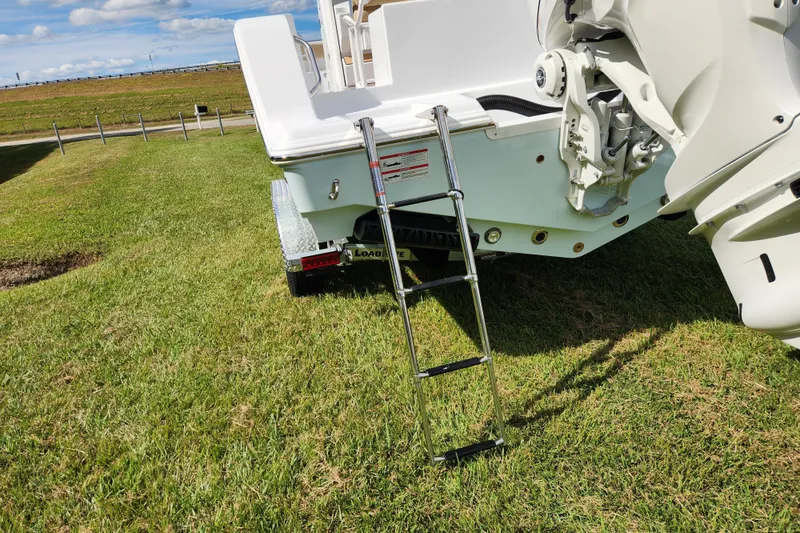 Slide: The Image of 2026 Sportsman Open 232 Center Console boat with ladder on grassy field. - 7