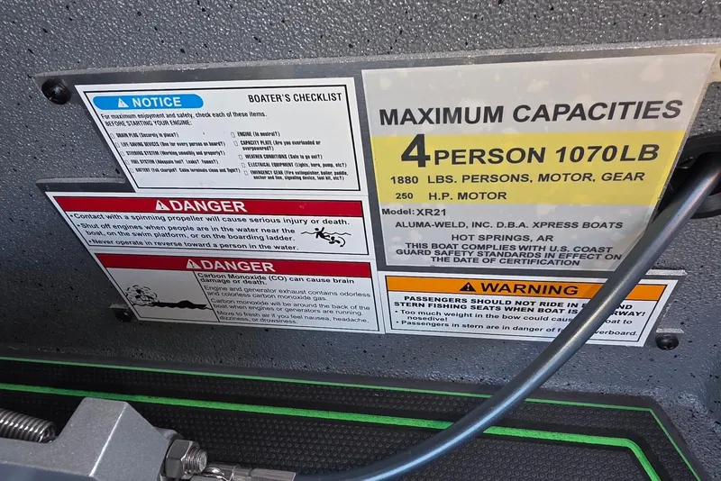 Slide: The Image of Boat safety and capacity labels for Xpress XR21, 2026 model, detailing weight limits and warnings. - 25