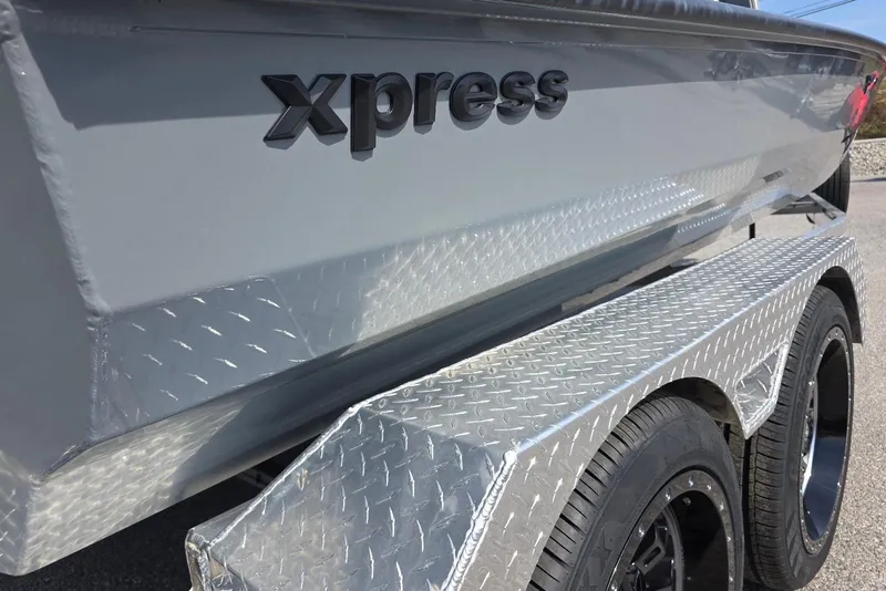 Slide: The Image of 2026 Xpress XR21 boat on a diamond plate trailer, showcasing sleek design. - 6