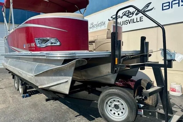 Slide: The Image of 2020 Avalon 220 Cruise pontoon boat on trailer, red exterior, parked outdoors. - 2