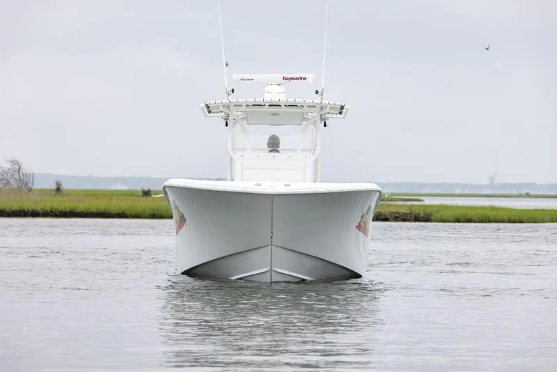 Slide: The Image of 2017 Yellowfin 32 Offshore boat on calm water, front view, overcast sky. - 2