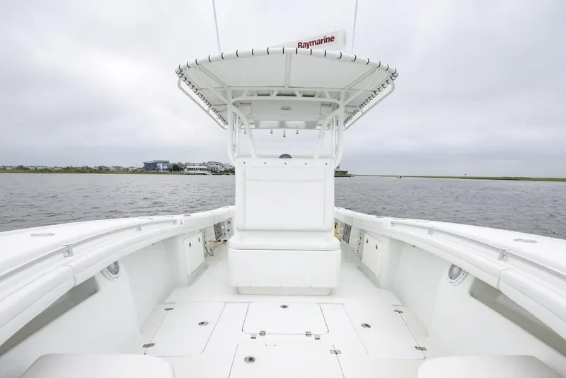 Slide: The Image of 2017 Yellowfin 32 Offshore boat on calm water, featuring spacious deck and Raymarine equipment. - 7