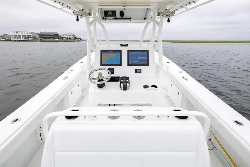 Slide: The Image of 2017 Yellowfin 32 Offshore boat interior with navigation screens and steering wheel on calm water. - 9