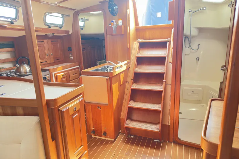 Slide: The Image of Interior of 2015 Tartan 3700 CCR sailboat with wooden cabinetry and compact kitchen. - 5