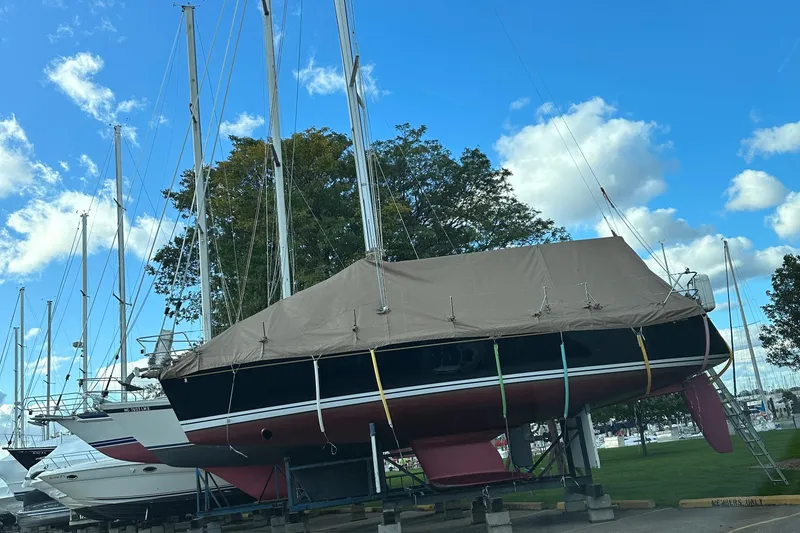 Slide: The Image of 2015 Tartan 3700 CCR sailboat covered and docked, surrounded by other boats, under a blue sky. - 8