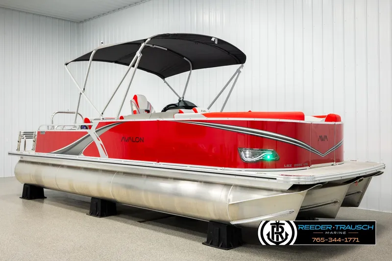 Slide: The Image of 2026 Avalon LSZ Vrl pontoon boat in showroom, featuring sleek red design and canopy. - 3