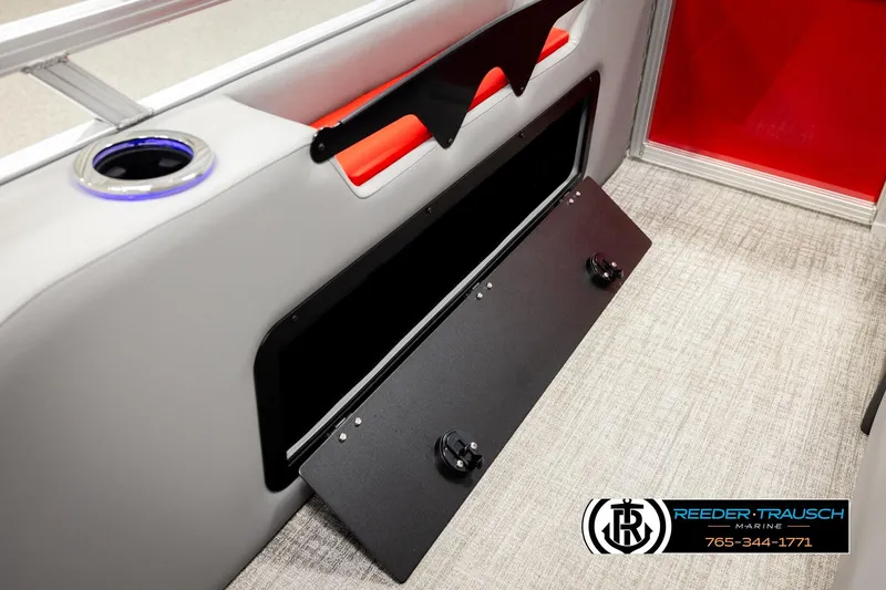 Slide: The Image of 2026 Avalon LSZ Vrl boat interior with storage compartment and cup holder, Reeder-Trausch Marine branding. - 30