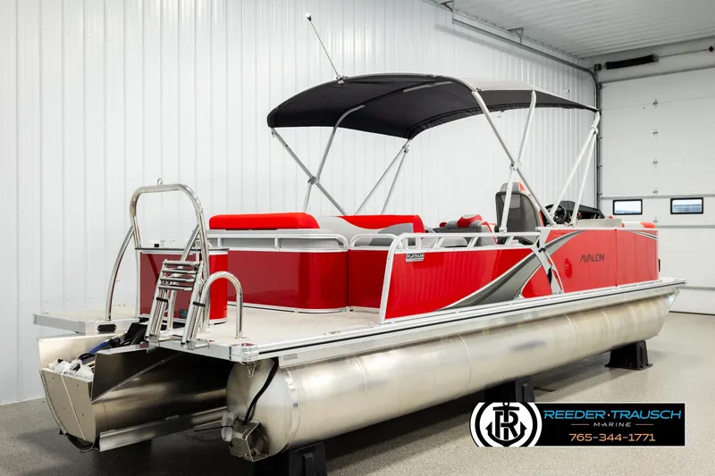 Slide: The Image of 2026 Avalon LSZ Vrl pontoon boat in a showroom, featuring red and silver design. - 6