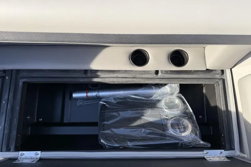 Slide: The Image of Storage compartment in 2026 Premier 220 Sunscape RF boat, featuring cup holders and accessories. - 9
