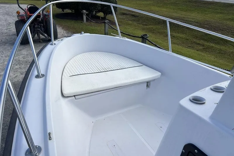 Slide: The Image of 1997 Boston Whaler Outrage 17 boat interior with cushioned seating and railing. - 11