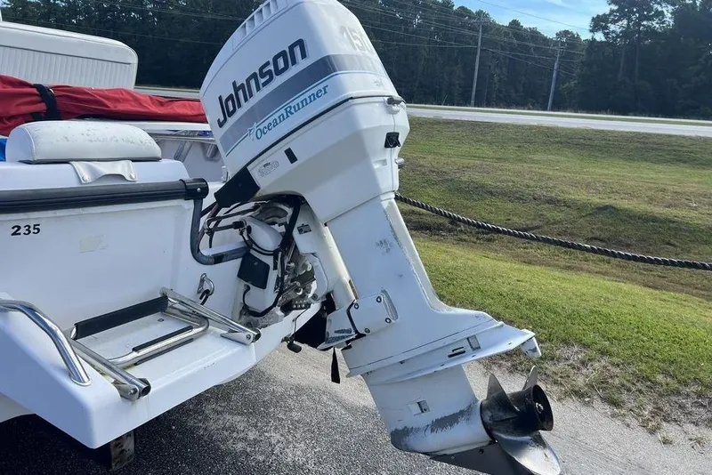 Slide: The Image of 1997 Boston Whaler Outrage 17 with Johnson OceanRunner outboard motor, parked on roadside. - 13