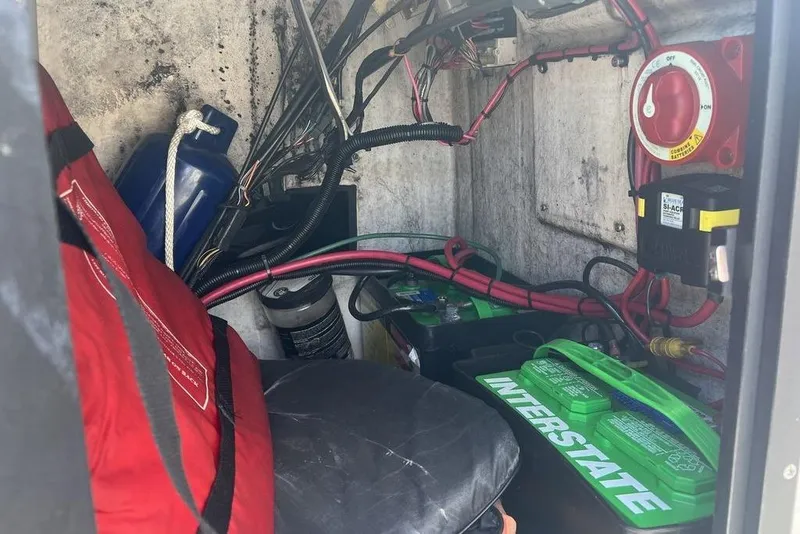 Slide: The Image of 1997 Boston Whaler Outrage 17 battery compartment with wiring and safety equipment. - 14