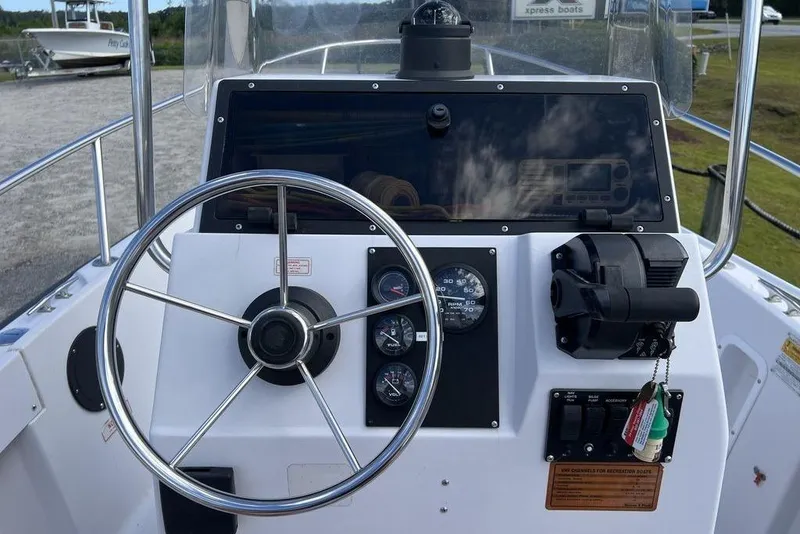 Slide: The Image of 1997 Boston Whaler Outrage 17 boat dashboard with steering wheel and control panel. - 7