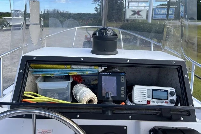 Slide: The Image of 1997 Boston Whaler Outrage 17 dashboard with navigation equipment and storage. - 8