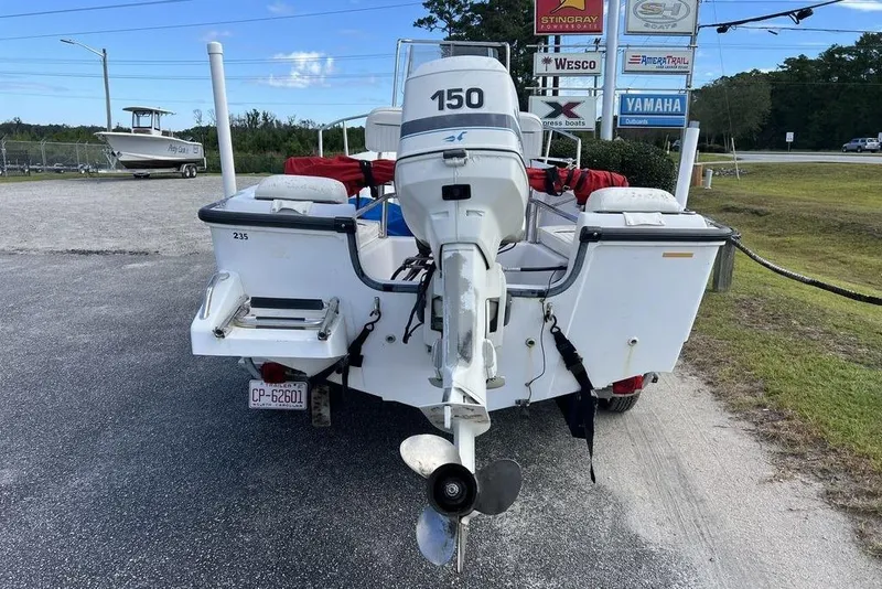 Slide: The Image of 1997 Boston Whaler Outrage 17 boat with 150 HP engine, parked outdoors. - 9