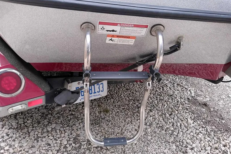 Slide: The Image of 2015 Ranger Z521C boat ladder and warning labels on gravel surface. - 14