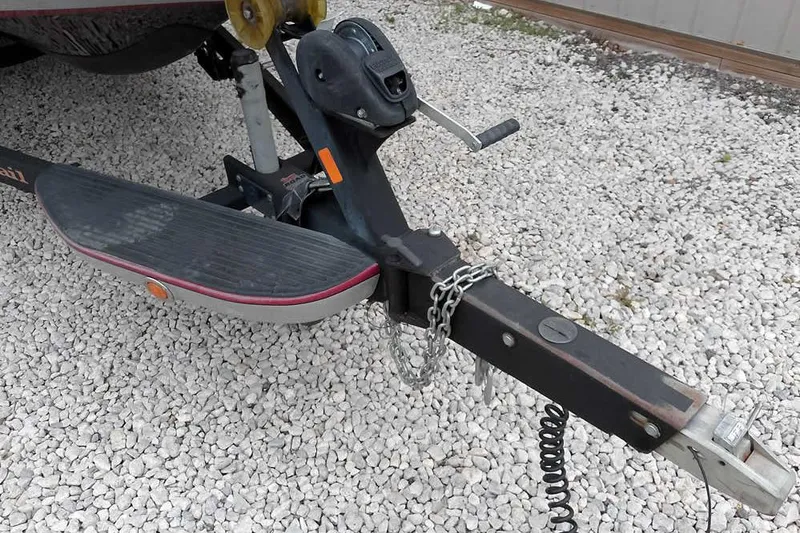 Slide: The Image of 2015 Ranger Z521C trailer hitch on gravel surface, featuring chains and winch handle. - 6