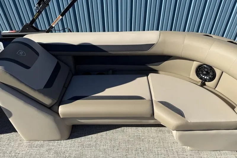 Slide: The Image of Luxurious seating on 2026 Premier 220 Sunscape RF XLC boat, featuring beige upholstery and speaker. - 27