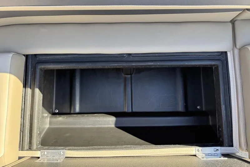 Slide: The Image of Open storage compartment in 2026 Premier 220 Sunscape RF XLC boat, featuring beige upholstery. - 32