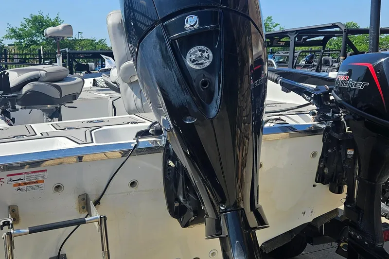 Slide: The Image of 2020 Larson FX 2020 Tiller boat with dual outboard motors, docked outdoors. - 5