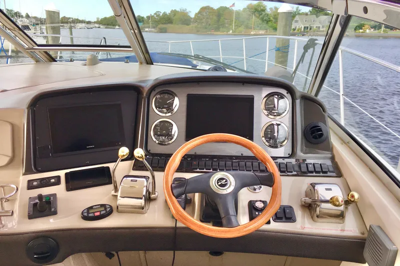 Slide: The Image of 2005 Sea Ray 420 Sundancer helm with wooden steering wheel and modern controls. - 12