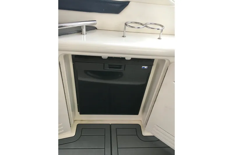 Slide: The Image of 2005 Sea Ray 420 Sundancer interior with built-in mini fridge and cup holders. - 25