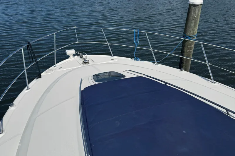 Slide: The Image of 2005 Sea Ray 420 Sundancer yacht bow view with blue cover and railing. - 3