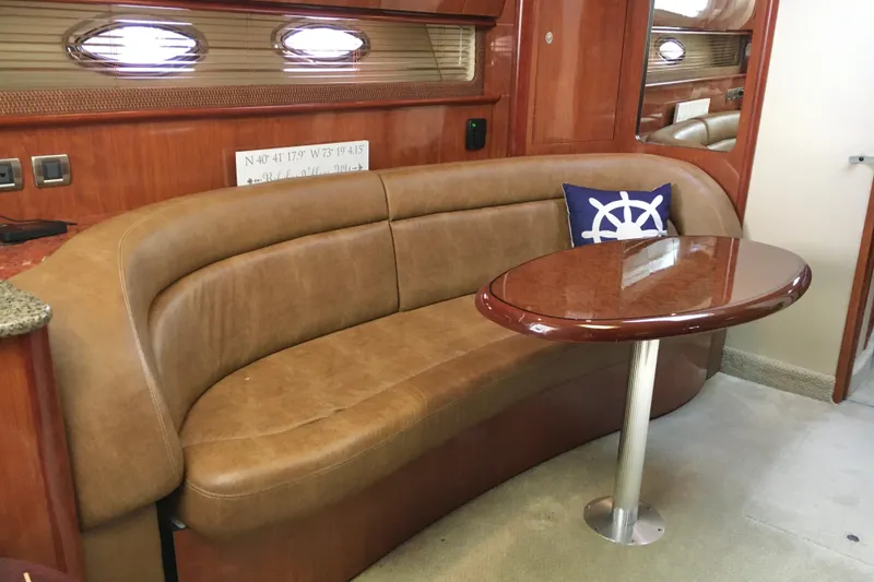 Slide: The Image of Luxurious interior of 2005 Sea Ray 420 Sundancer with leather seating and wooden table. - 31