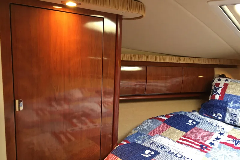 Slide: The Image of Luxurious 2005 Sea Ray 420 Sundancer cabin with wooden cabinetry and nautical-themed bedding. - 42