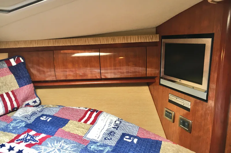Slide: The Image of Cozy cabin interior of 2005 Sea Ray 420 Sundancer with TV and colorful bedding. - 43