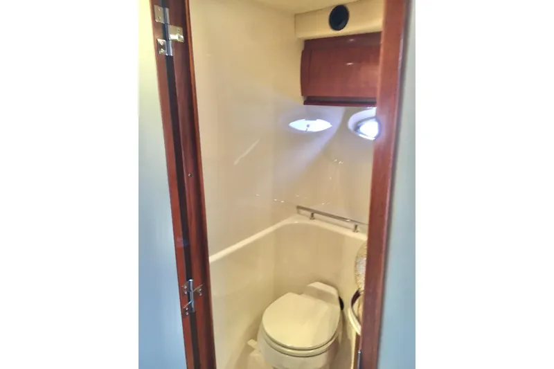 Slide: The Image of 2005 Sea Ray 420 Sundancer yacht bathroom with wooden door and compact design. - 49