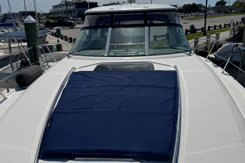 Slide: The Image of 2005 Sea Ray 420 Sundancer yacht with blue sunpad, docked at marina. - 5