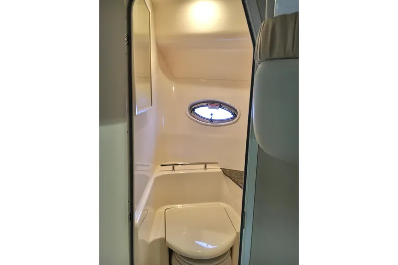 Slide: The Image of 2005 Sea Ray 420 Sundancer bathroom interior with porthole window and compact design. - 58