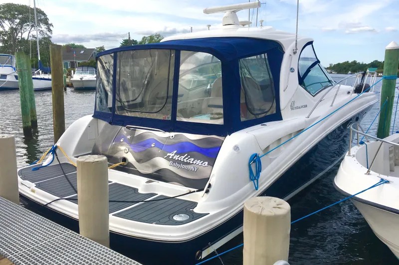 Slide: The Image of 2005 Sea Ray 420 Sundancer yacht docked at marina, featuring sleek design and blue canopy. - 6