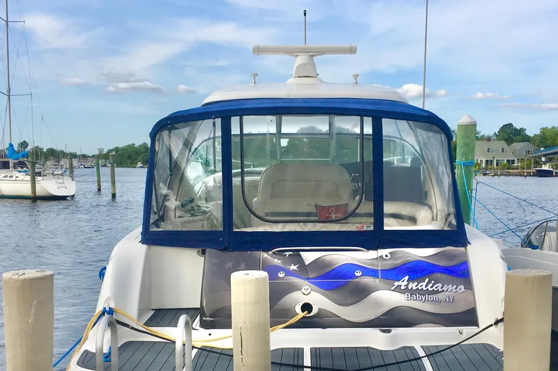Slide: The Image of 2005 Sea Ray 420 Sundancer docked at a marina, featuring a blue canopy. - 8