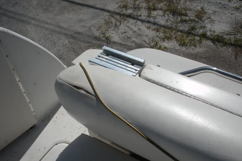 Slide: The Image of 2000 Sea Ray 240 Sundancer boat interior with white upholstery and metal fittings. - 16