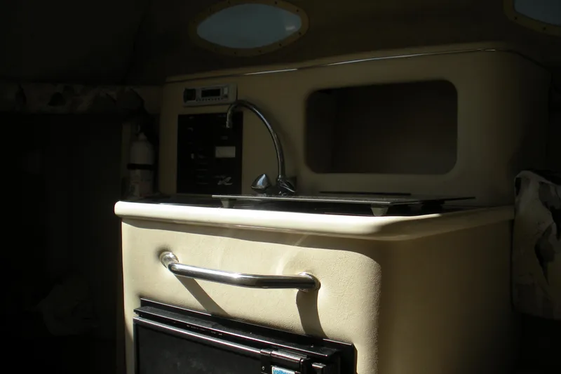 Slide: The Image of 2000 Sea Ray 240 Sundancer cabin interior with sink and storage area. - 4