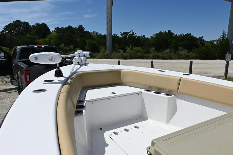 Slide: The Image of 2023 Clark Sound 24 boat interior with tan seating, parked near a truck. - 10