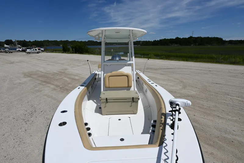 Slide: The Image of 2023 Clark Sound 24 boat on sandy shore, clear sky, and lush greenery. - 14