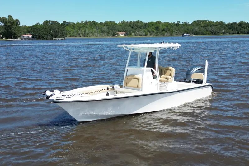 Slide: The Image of 2024 Clark Sound 24 boat cruising on a calm lake with lush green shoreline. - 4