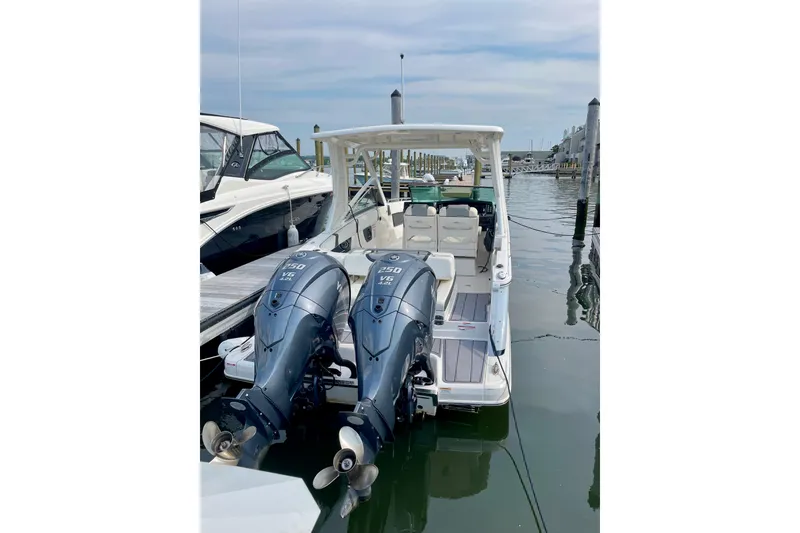 Slide: The Image of 2023 Chaparral 280 OSX boat with dual outboard engines docked at marina. - 23