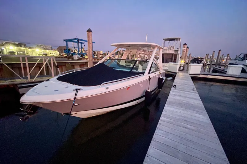 Slide: The Image of 2023 Chaparral 280 OSX boat docked at marina during twilight. - 25