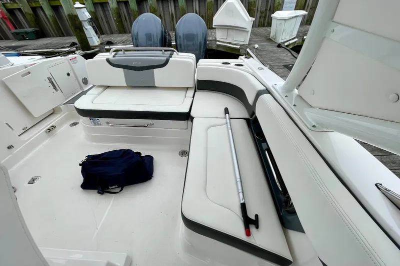 Slide: The Image of 2023 Chaparral 280 OSX boat interior with seating, backpack, and dock view. - 37