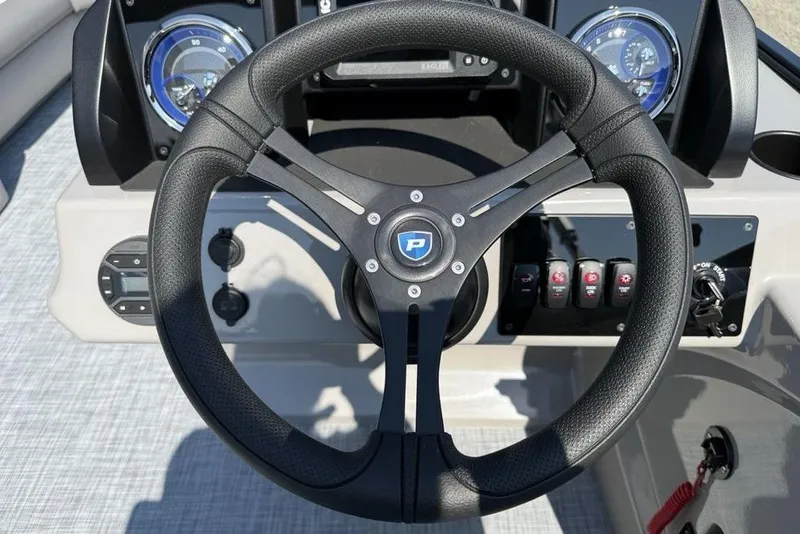 Slide: The Image of Steering wheel of 2026 Premier 220 Sunscape RF boat with dashboard controls. - 15