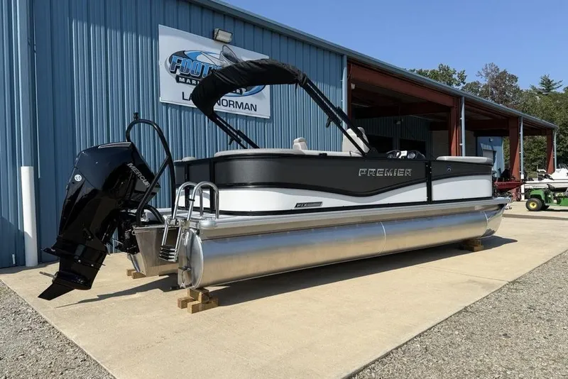 Slide: The Image of 2026 Premier 220 Sunscape RF pontoon boat displayed outside a marine dealership. - 2